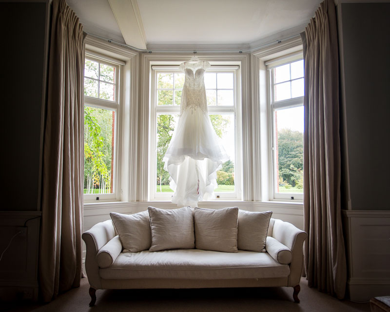 Wedding dress hanging in a window in the bridal suite